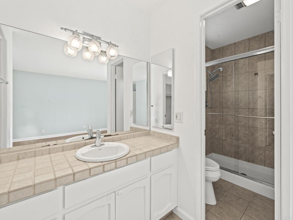 2639 Pirineos Way, Unit 231 Carlsbad, CA 92009 - Photo 19 of 34 a bathroom with a sink a toilet and shower