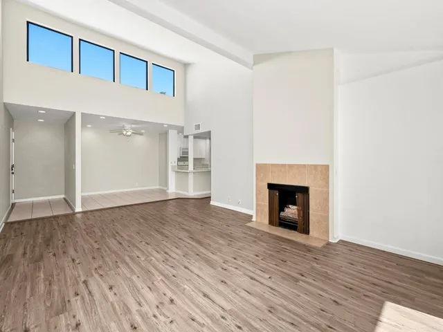 a view of a livingroom with wooden floor and a fireplace