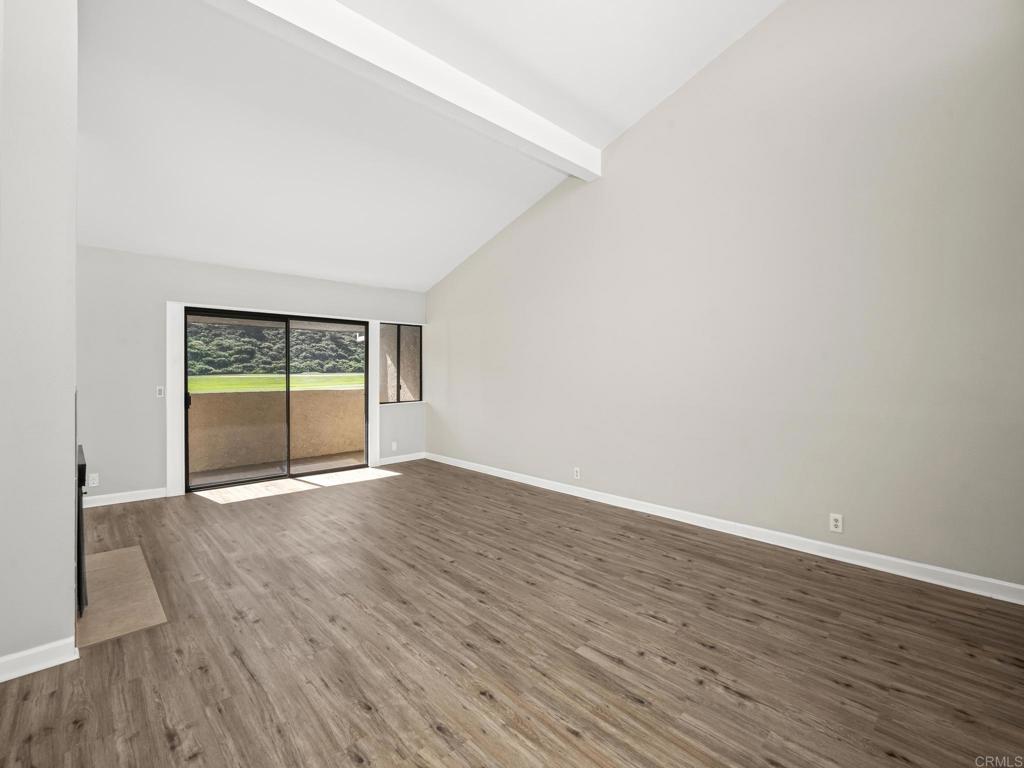 2639 Pirineos Way, Unit 231 Carlsbad, CA 92009 - Photo 5 of 34 an empty room with wooden floor and windows