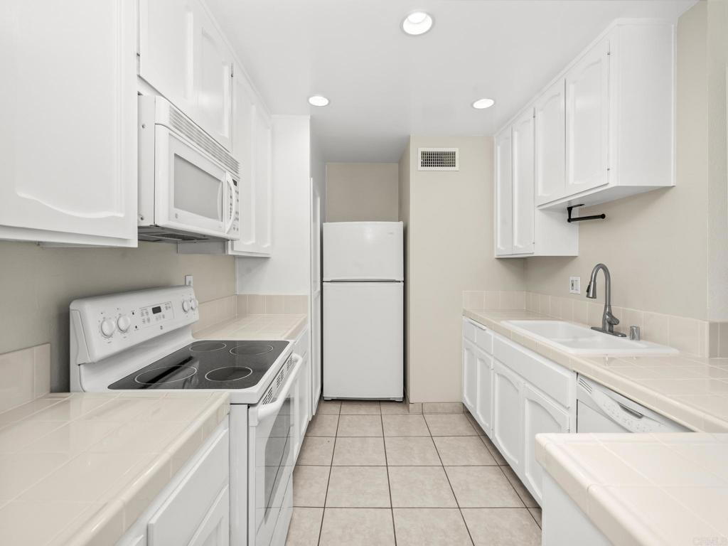 2639 Pirineos Way, Unit 231 Carlsbad, CA 92009 - Photo 7 of 34 a kitchen with a sink a stove and refrigerator