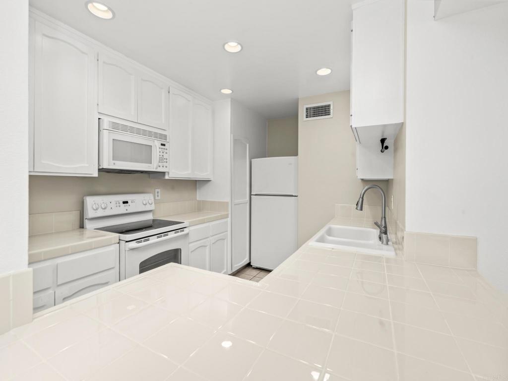 2639 Pirineos Way, Unit 231 Carlsbad, CA 92009 - Photo 8 of 34 a kitchen with stainless steel appliances granite countertop a refrigerator sink and stove