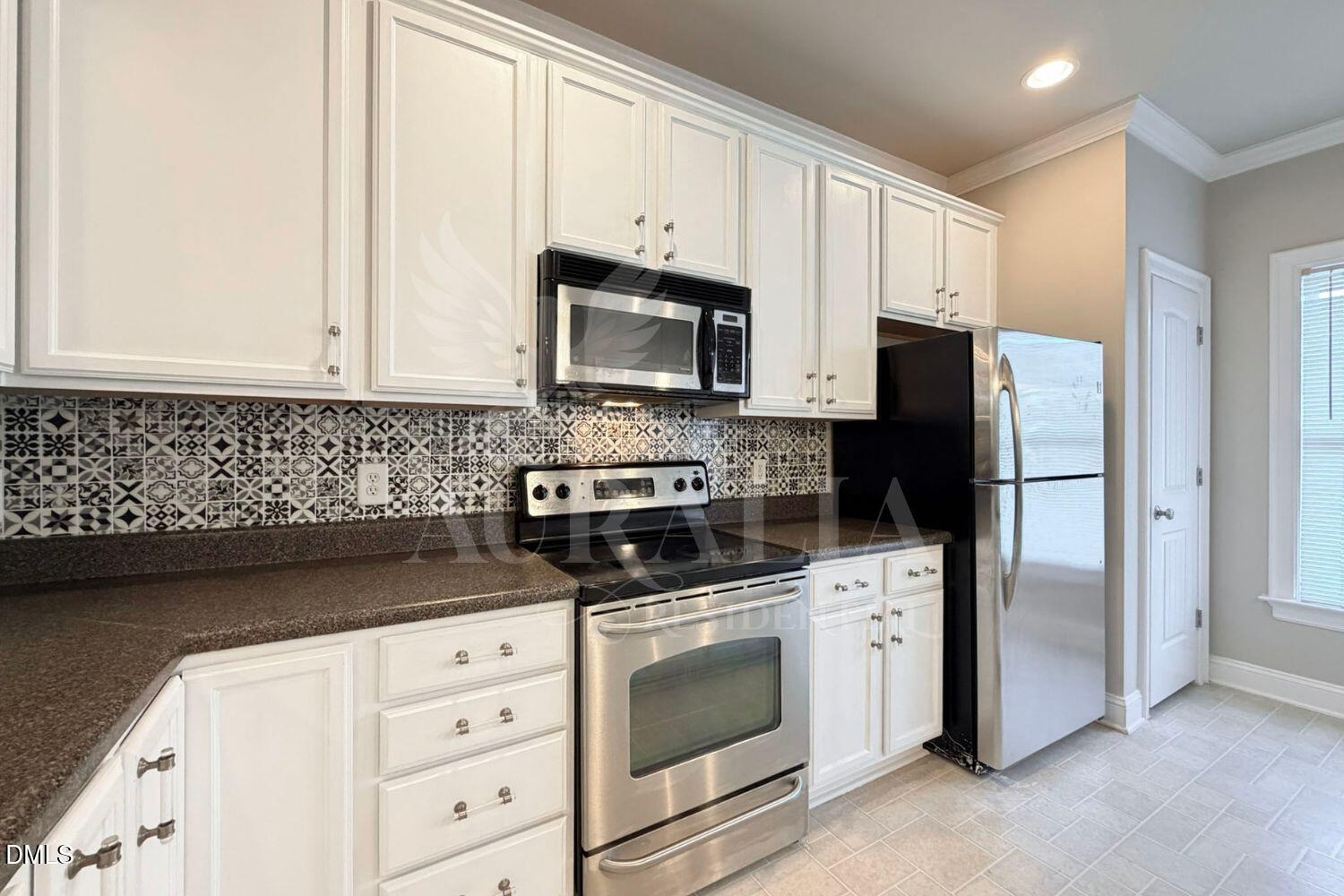 7754 ACC Boulevard Raleigh, NC 27617 - Photo 14 of 41 a kitchen with white cabinets and black appliances