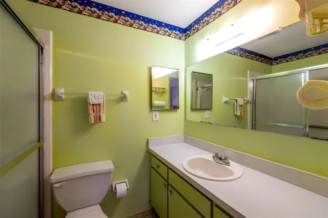 a bathroom with a sink mirror vanity and toilet