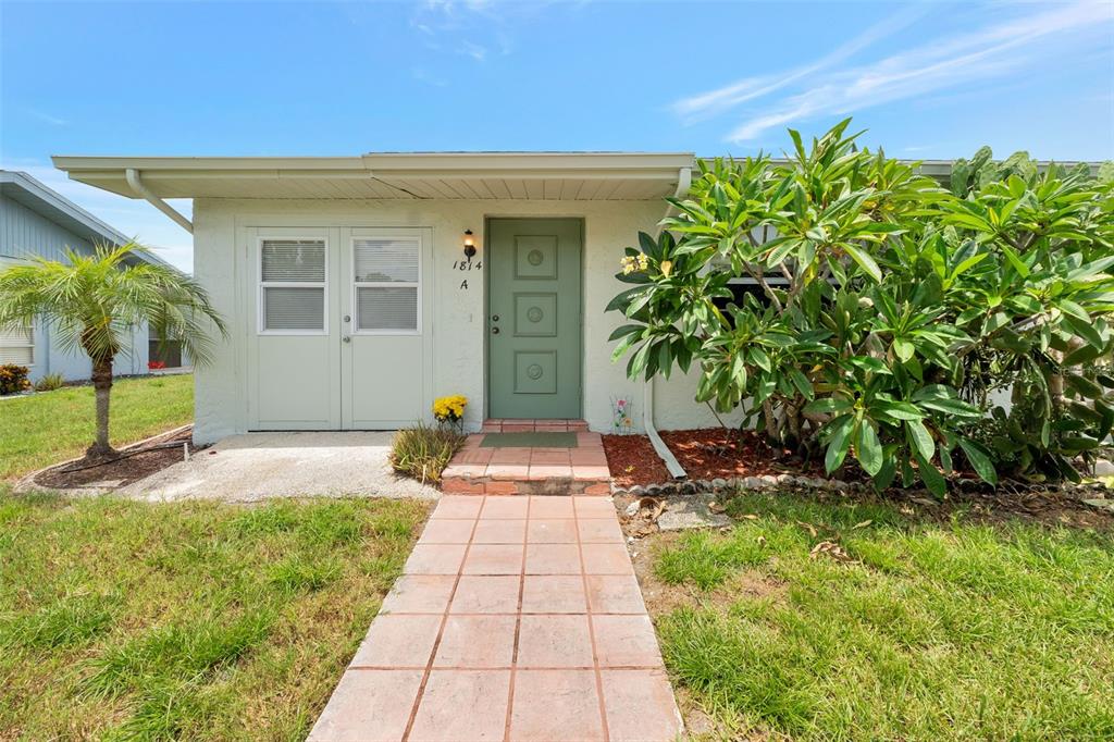 1814 Fox Hunt Drive, Unit A Sun City Center, FL 33573 - Photo 2 of 23 a front view of a house with a garden