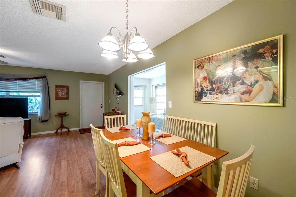 1814 Fox Hunt Drive, Unit A Sun City Center, FL 33573 - Photo 4 of 23 a view of a dining room with furniture a chandelier and wooden floor