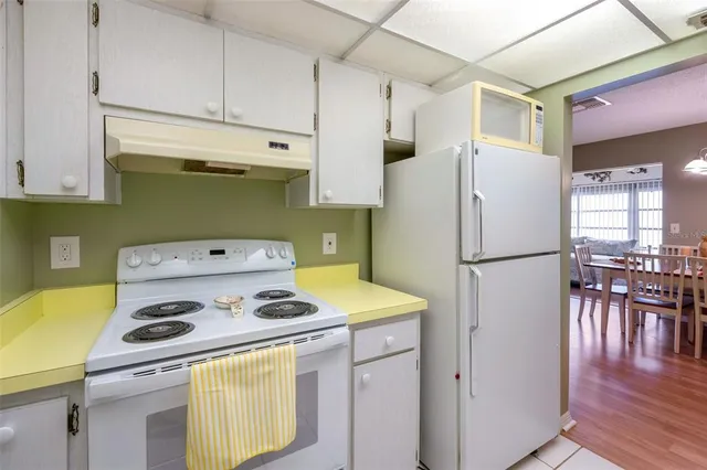 a kitchen with a refrigerator and a stove top oven