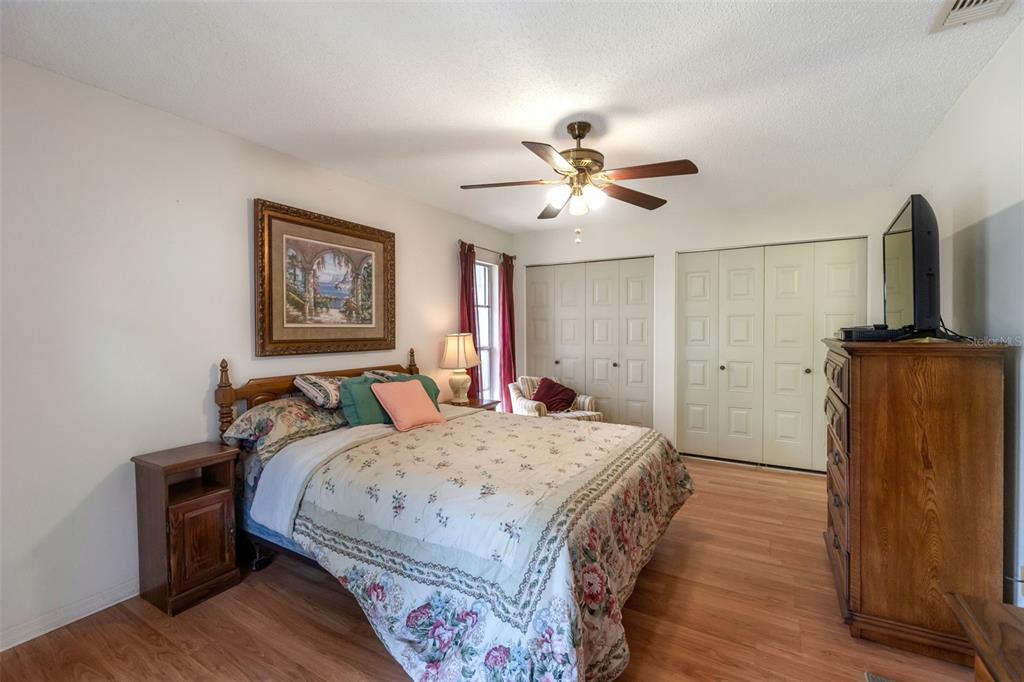 1814 Fox Hunt Drive, Unit A Sun City Center, FL 33573 - Photo 9 of 23 a bedroom with a bed dresser and wooden floor