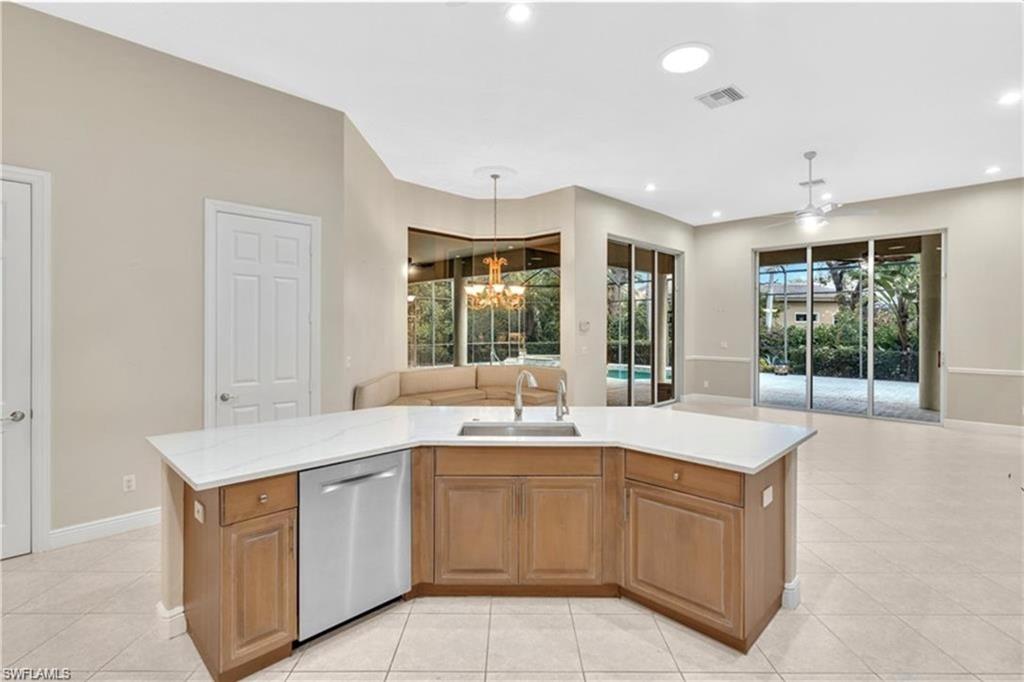 6676 Glen Arbor Way Naples, FL 34119 - Photo 12 of 23 a kitchen with a sink stove and cabinets