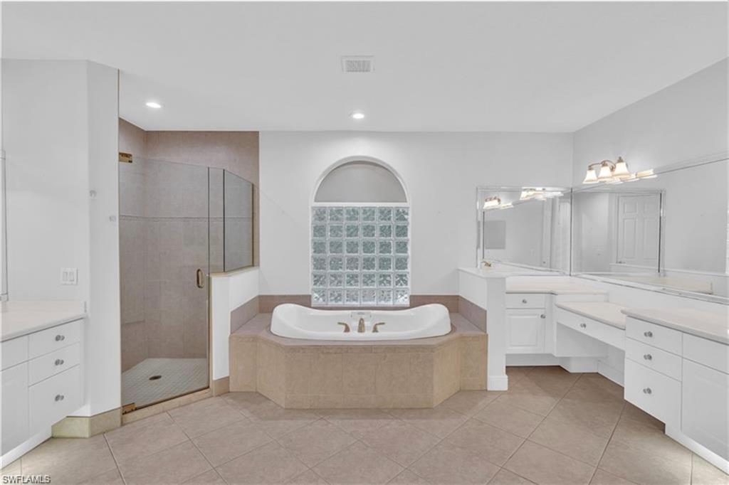 6676 Glen Arbor Way Naples, FL 34119 - Photo 15 of 23 a spacious bathroom with a double vanity sink a mirror and a bathtub