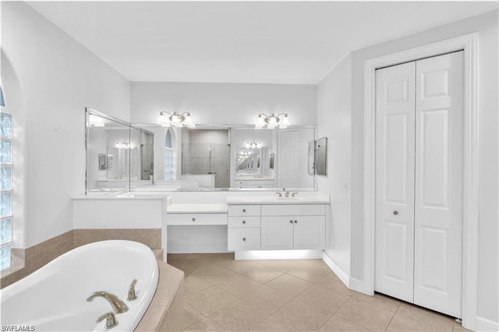 6676 Glen Arbor Way Naples, FL 34119 - Photo 16 of 23 a bathroom with a tub sink and mirror