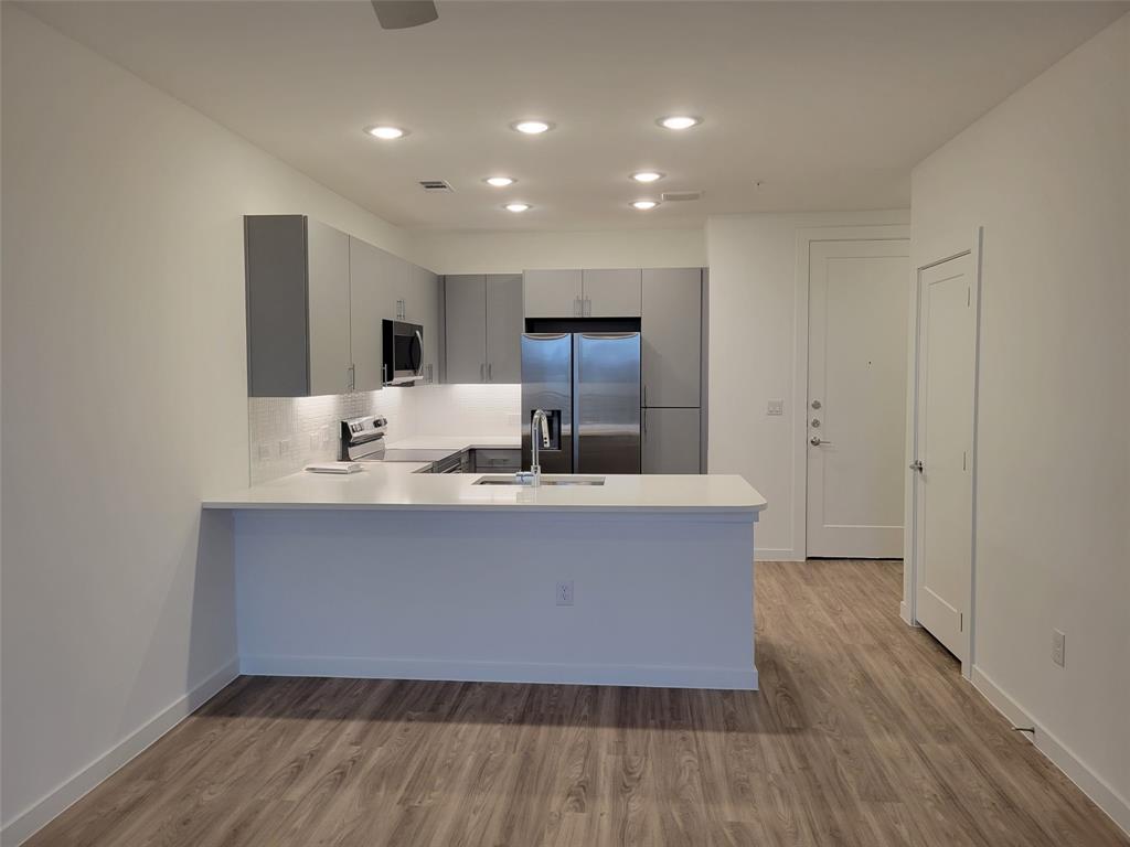 4801 Springdale Road, Unit 2211 Austin, TX 78723 - Photo 5 of 19 A contemporary kitchen space boasts sleek stainless steel appliances and abundant recessed lighting.