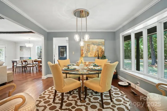 a dining room with furniture a chandelier and wooden floor