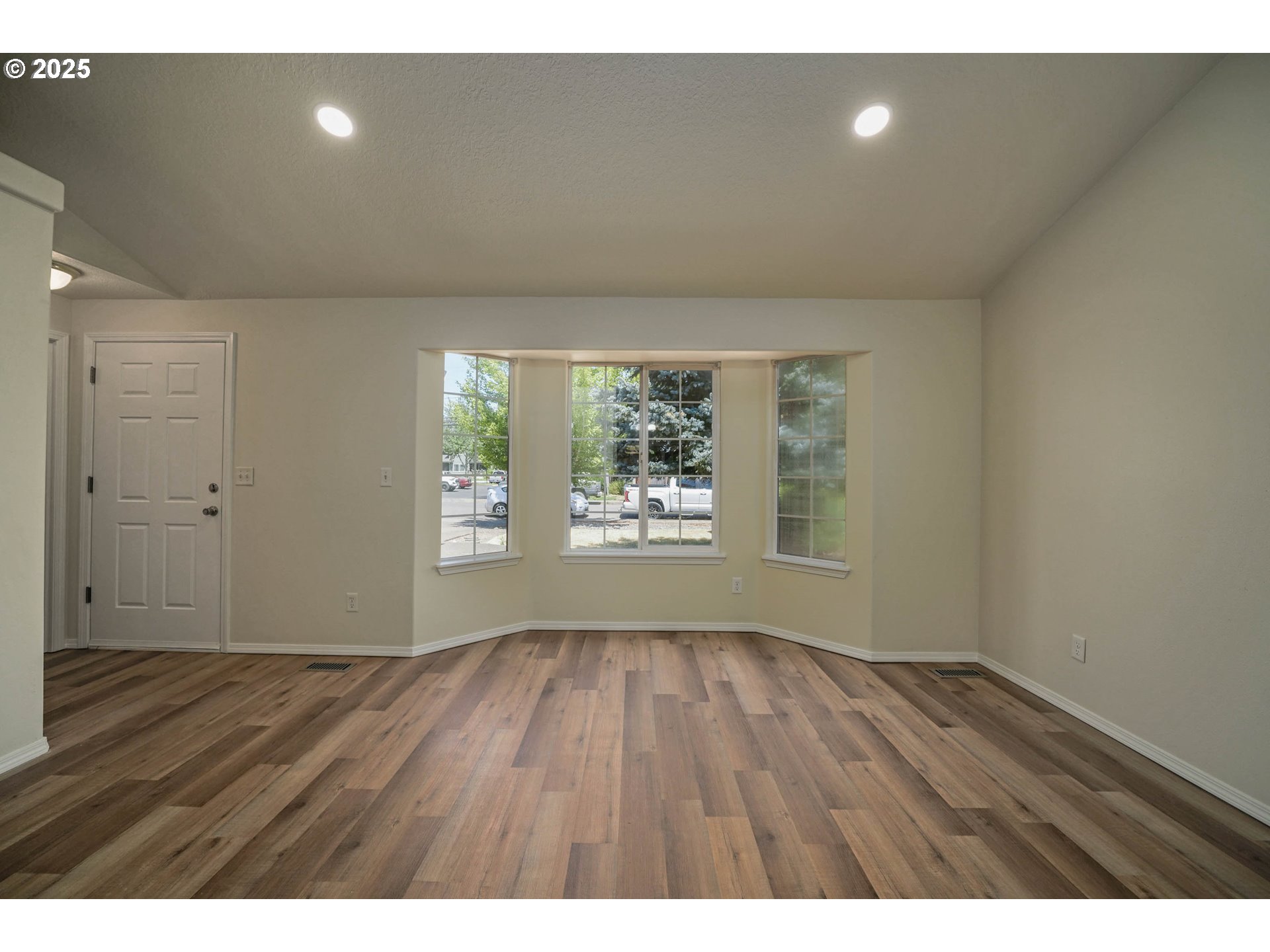 1033 E Street Independence, OR 97351 - Photo 6 of 36 a view of an empty room with wooden floor and a window