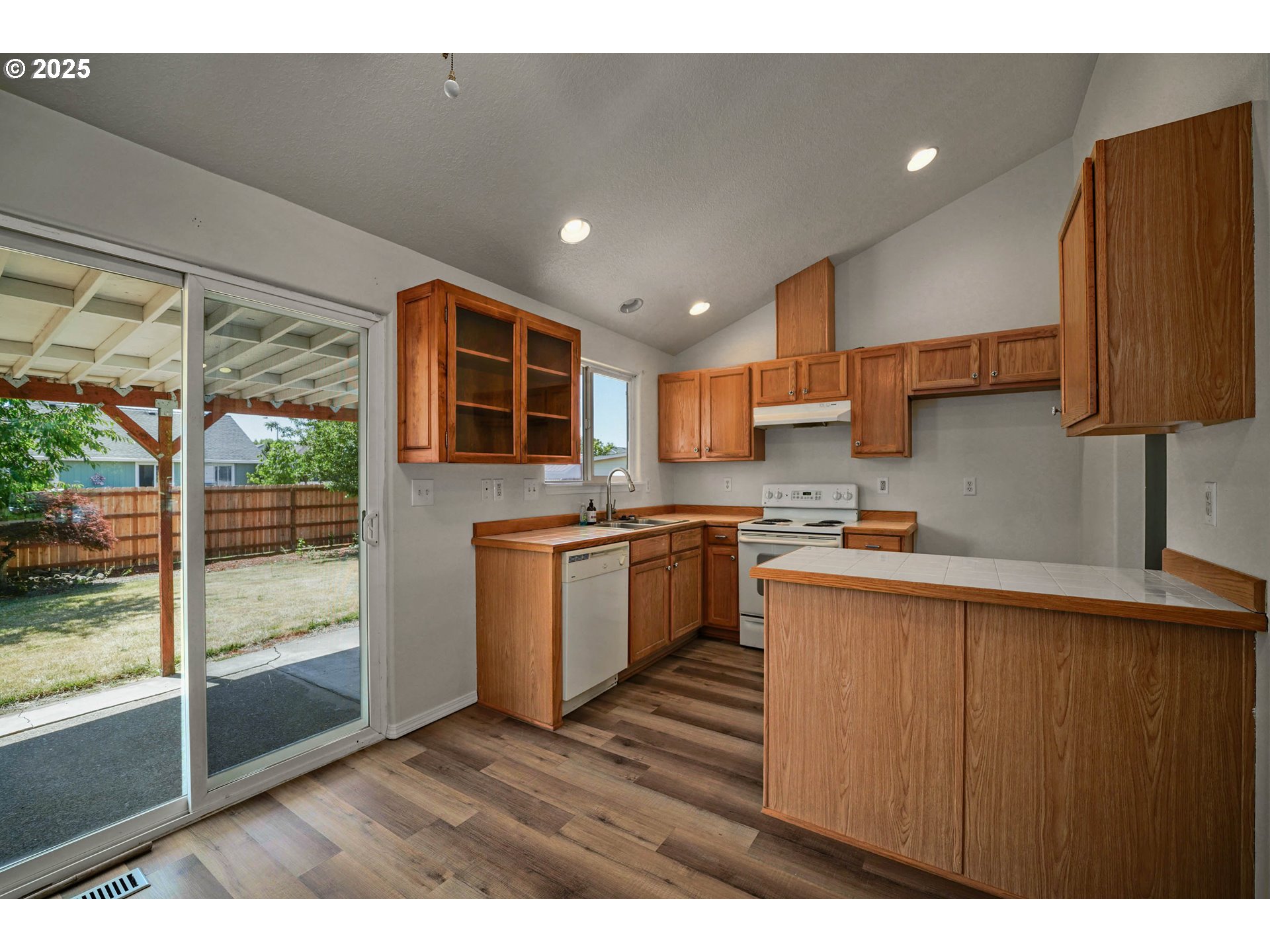 1033 E Street Independence, OR 97351 - Photo 10 of 36 a kitchen with kitchen island granite countertop a stove top oven a sink with wooden cabinets