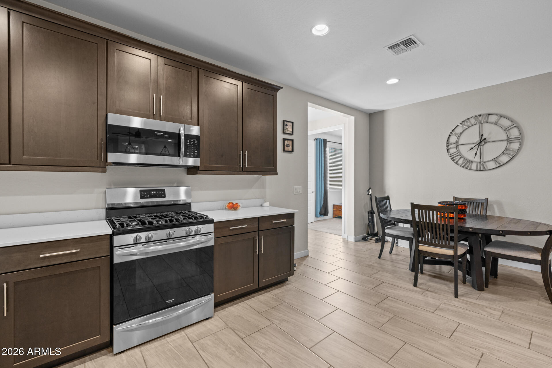 4143 East Appaloosa Road Gilbert, AZ 85296 - Photo 12 of 36 a kitchen with stainless steel appliances granite countertop a stove a sink a microwave and dining table