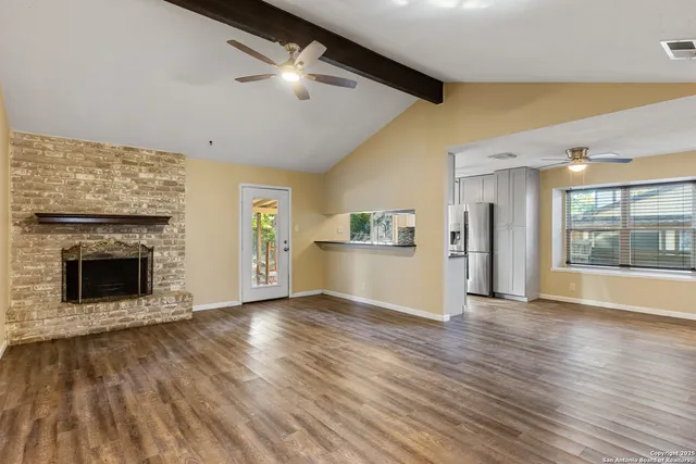 a view of an empty room with a fireplace and a window