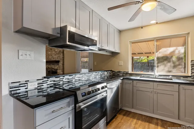 a kitchen with stainless steel appliances granite countertop a sink stove and cabinets
