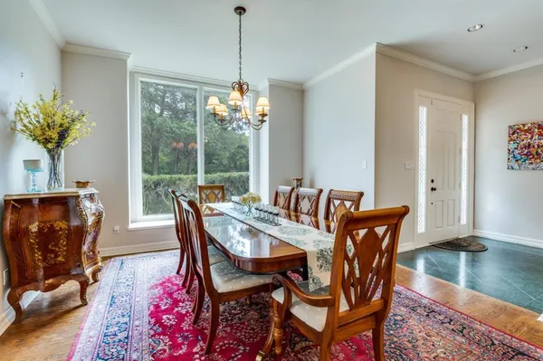a dining room with furniture a chandelier and wooden floor