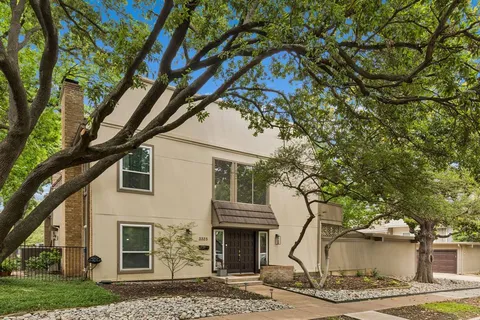a front view of a house with a tree