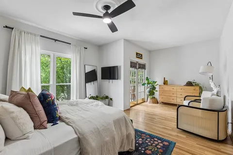 a bedroom with a bed a couch and a large window