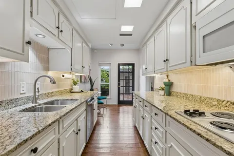 a kitchen with a sink stove top oven and cabinets