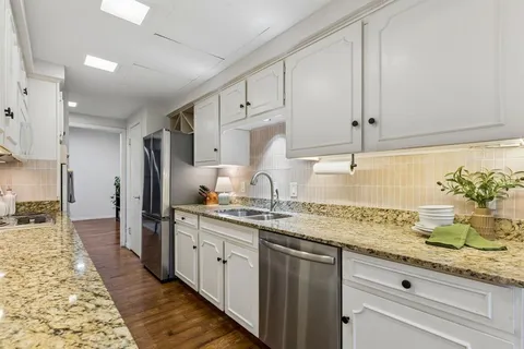 a kitchen with stainless steel appliances granite countertop a sink and cabinets