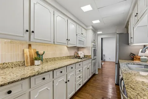 a kitchen with granite countertop a sink and cabinets