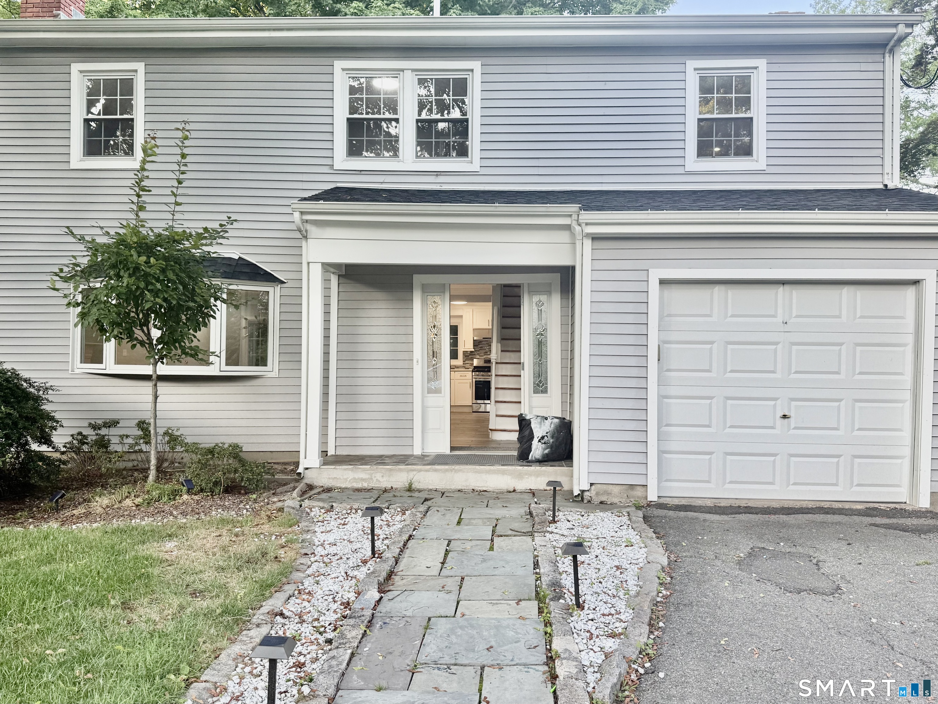 5 Griffith Road Greenwich, CT 06878 - Photo 34 of 34 Attractive front exterior with a spacious lawn, long driveway, ample parking, and an attached garage.