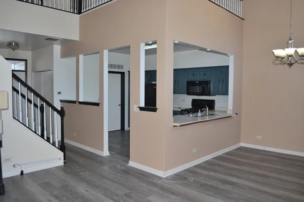 a view of a kitchen with wooden floor and a hallway