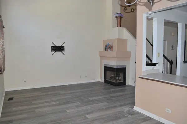 a view of a livingroom with wooden floor and a fireplace