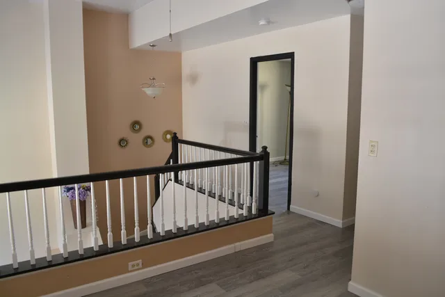 a view of a hallway with wooden floor and entryway