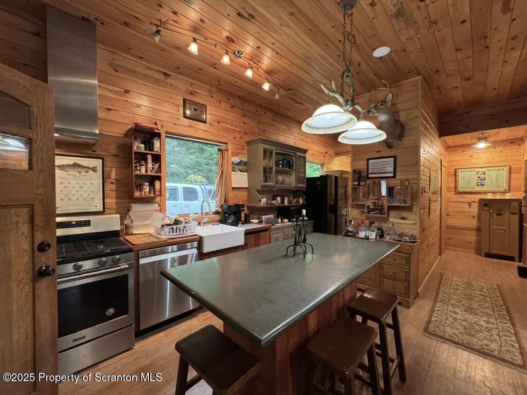498 Penn-York Road Starlight, PA 18461 - Photo 13 of 48 a kitchen with stainless steel appliances granite countertop a stove a refrigerator a kitchen island a sink dishwasher a dining table and chairs with wooden floor
