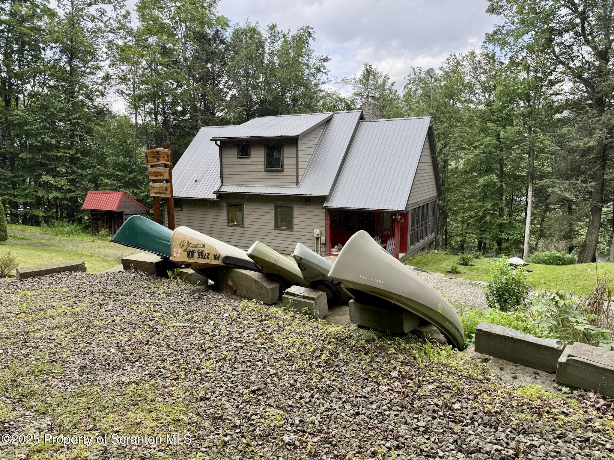 498 Penn-York Road Starlight, PA 18461 - Photo 5 of 48 a front view of a house with a yard fire pit table and chairs