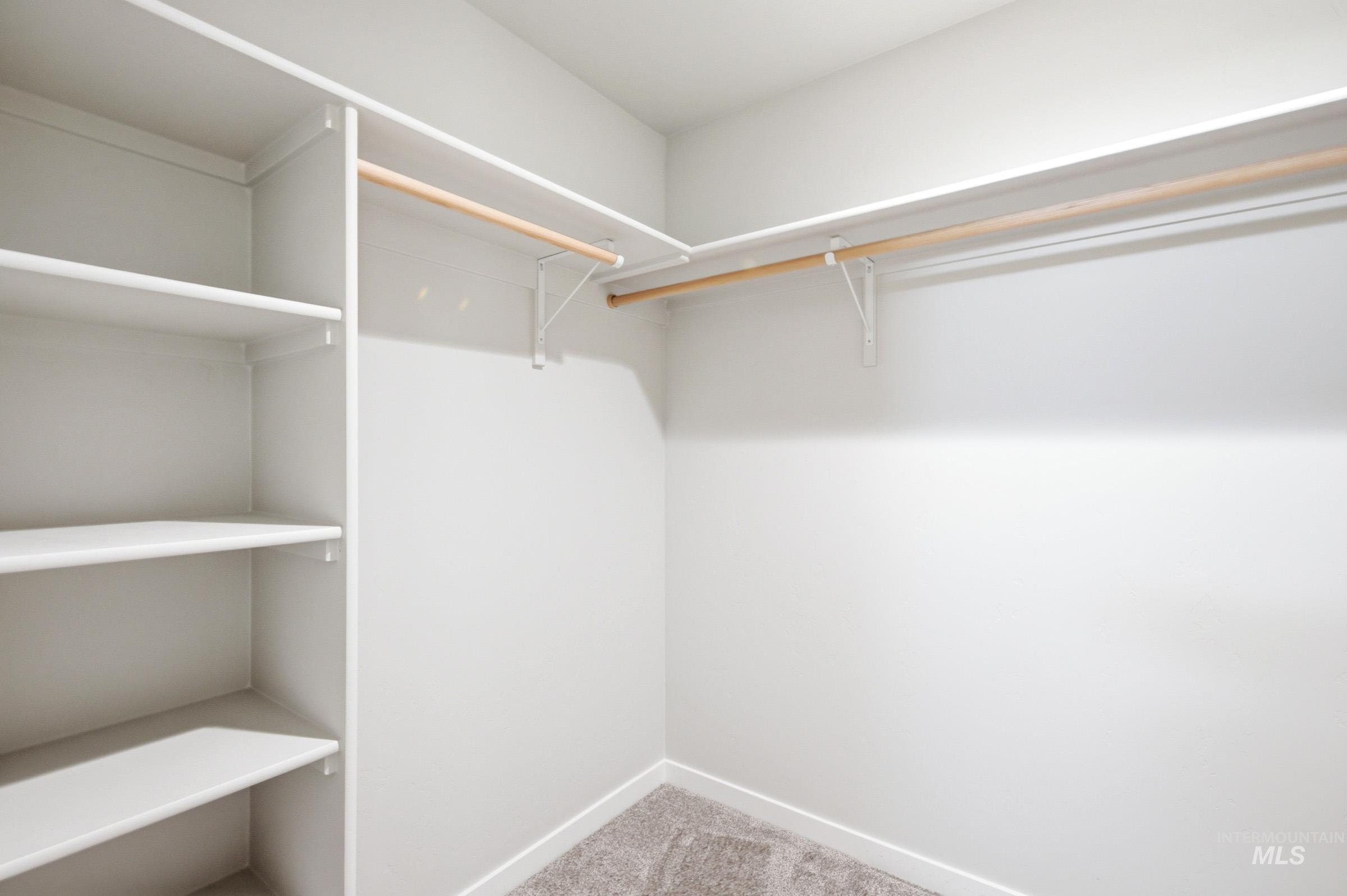 12877 Decatur Street Nampa, ID 83651 - Photo 21 of 22 Walk-in closet featuring built-in shelving, two hanging rods, and neutral-toned carpeting