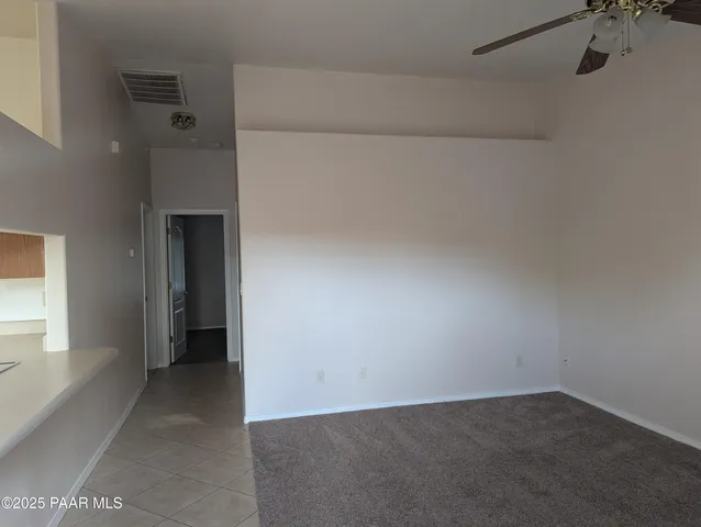 a view of a room with a chandelier fan and a ceiling fan
