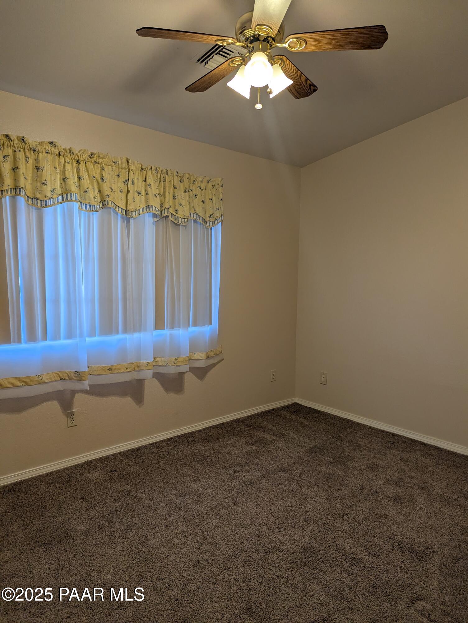 3325 East Yavapai Road, Unit B Prescott Valley, AZ 86314 - Photo 8 of 12 a view of a room with a chandelier fan and wooden floor