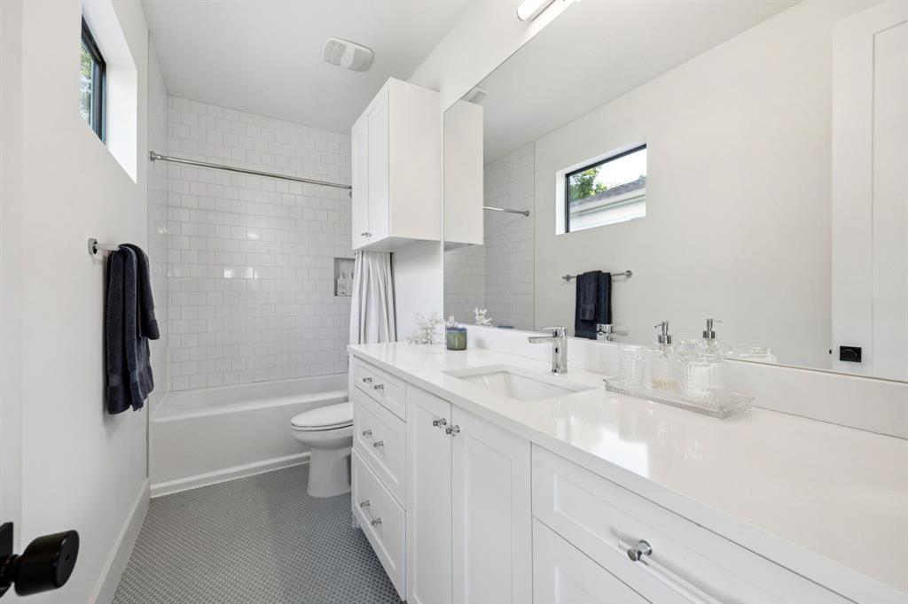 4419 Merrell Road Dallas, TX 75229 - Photo 18 of 27 a bathroom with a double vanity sink toilet and shower