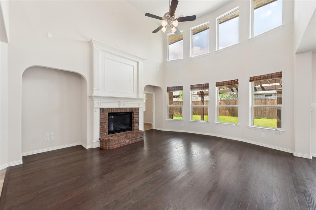 12571 Valley Spring Drive Frisco, TX 75035 - Photo 15 of 39 a view of an empty room with wooden floor fireplace and a window