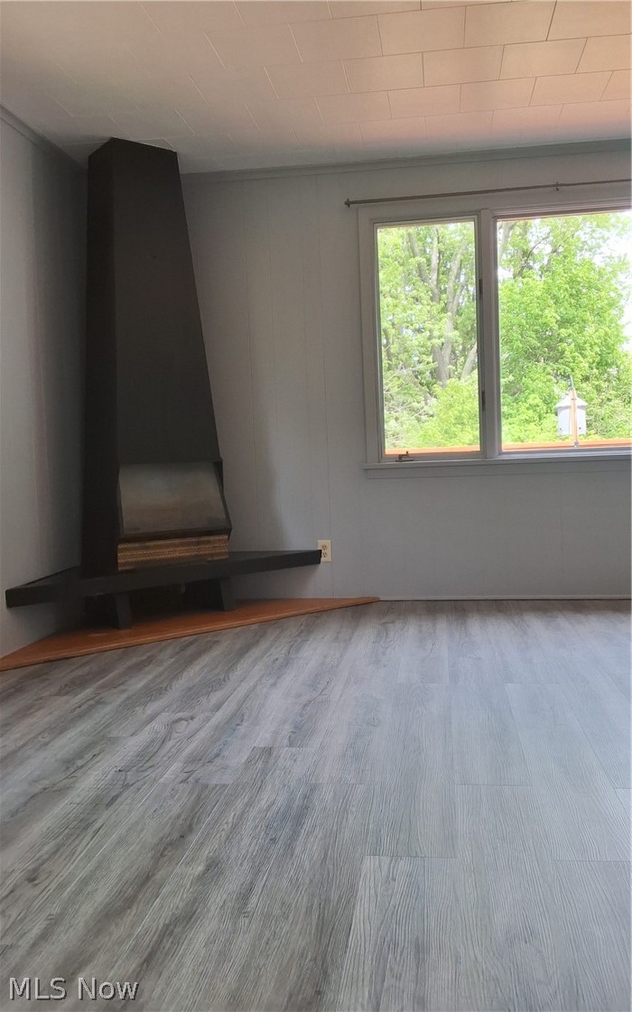 236 Bowland Road Mansfield, OH 44907 - Photo 23 of 34 Modern corner fireplace with a cantilevered hearth, light grey wood-finish flooring, and white paneled ceiling
