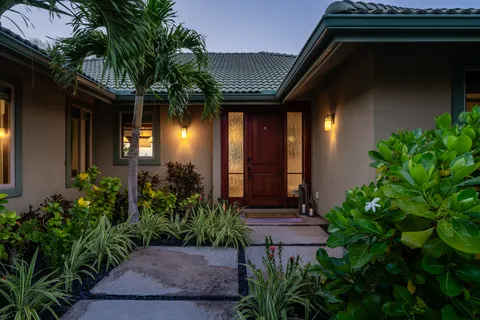 a view of a house with a small yard plants and large tree