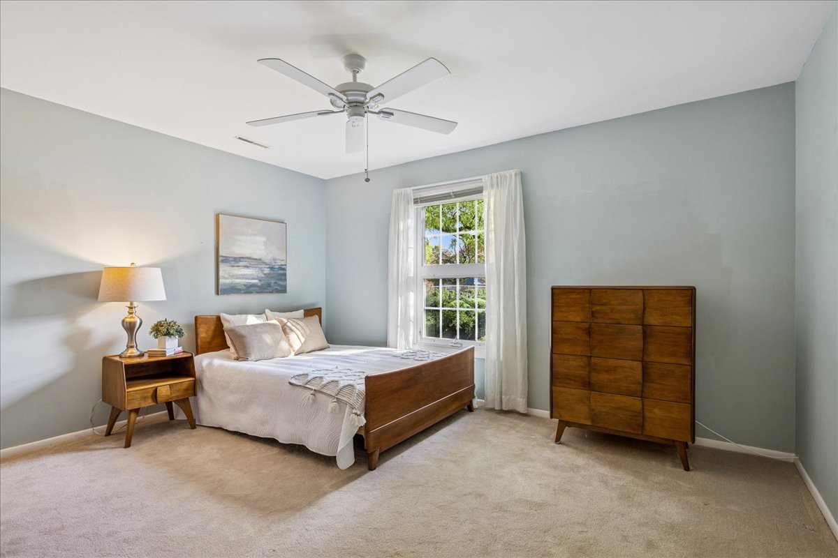 511 Coventry Lane, Unit 2 Crystal Lake, IL 60014 - Photo 12 of 40 a bedroom with a bed and a chandelier