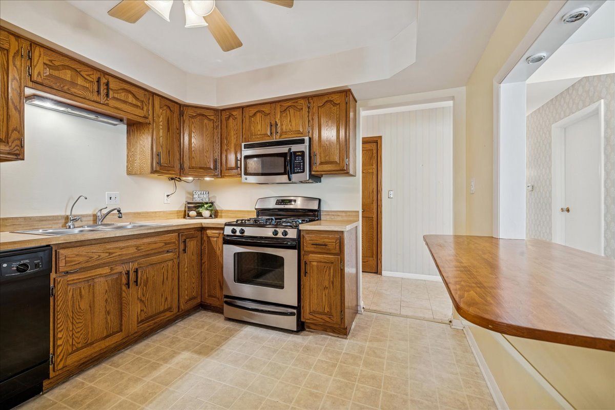 511 Coventry Lane, Unit 2 Crystal Lake, IL 60014 - Photo 5 of 40 a kitchen with stainless steel appliances granite countertop a stove a sink and a microwave