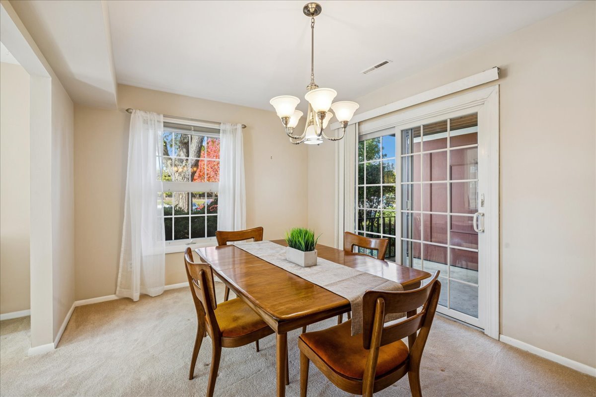 511 Coventry Lane, Unit 2 Crystal Lake, IL 60014 - Photo 8 of 40 a dining room with furniture a chandelier and window