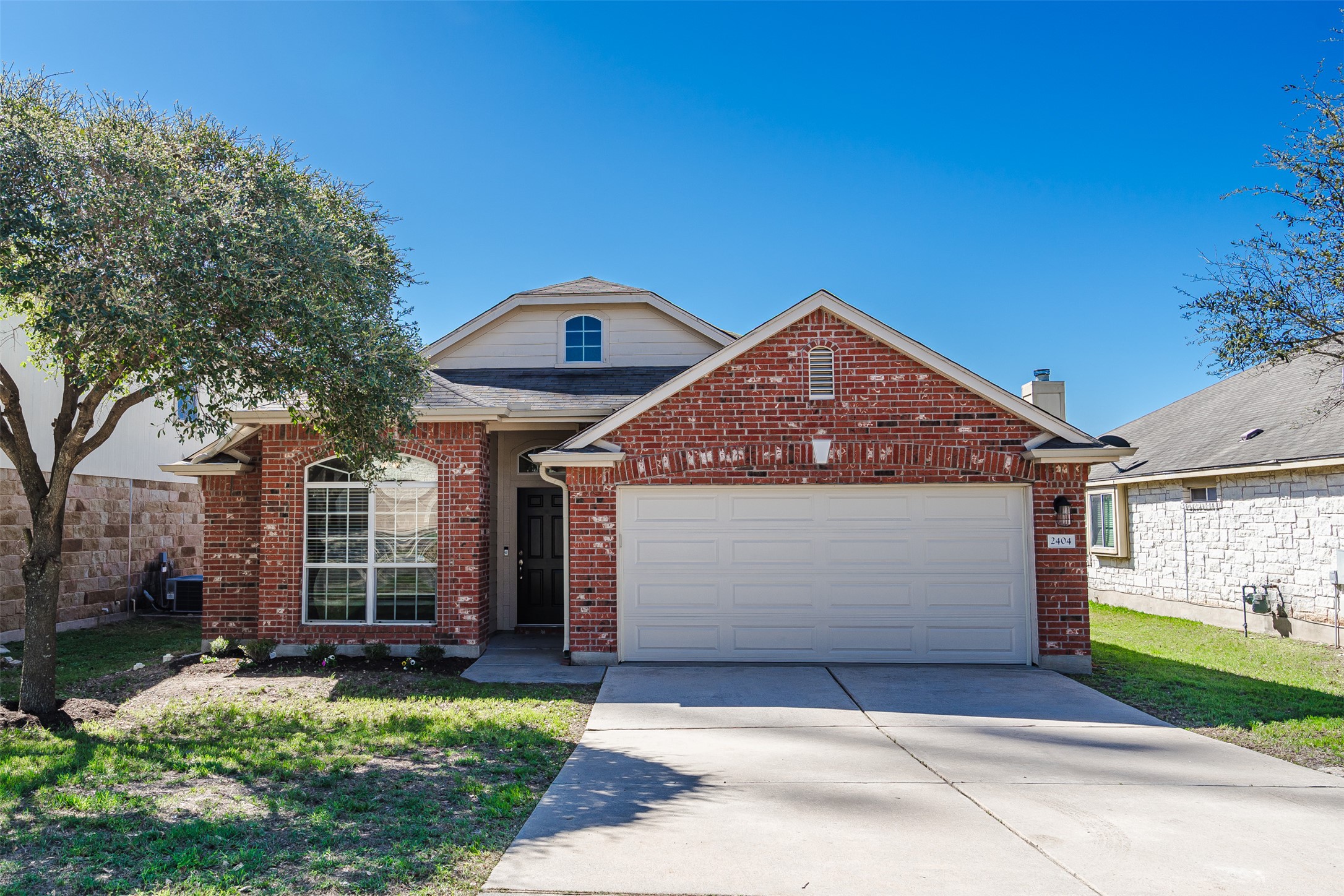 2404 Christoff Loop Austin, TX 78748 - Photo 1 of 24 View of front of house with driveway, brick siding, an attached garage, and a front yard