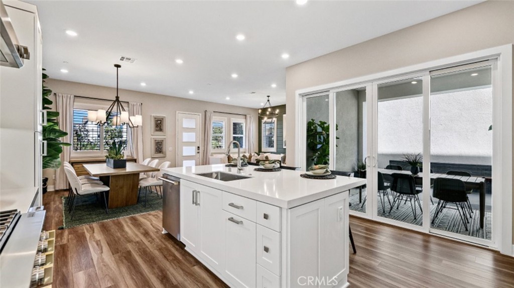 a kitchen with a sink stove and wooden floor