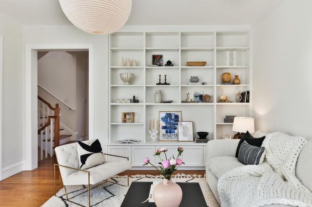 a dining room with furniture a chandelier and wooden floor