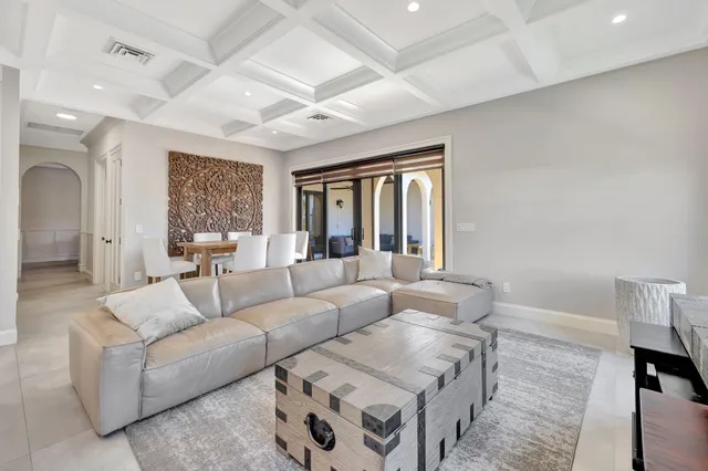 a living room with furniture a large window and wooden floor