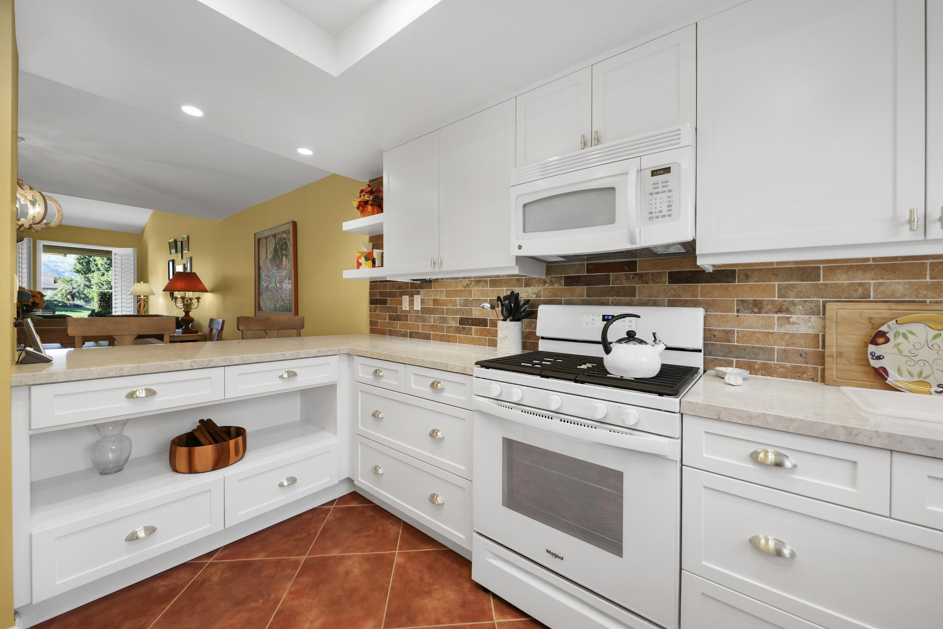 23 La Ronda Drive Rancho Mirage, CA 92270 - Photo 11 of 34 a kitchen with stainless steel appliances white cabinets and a sink