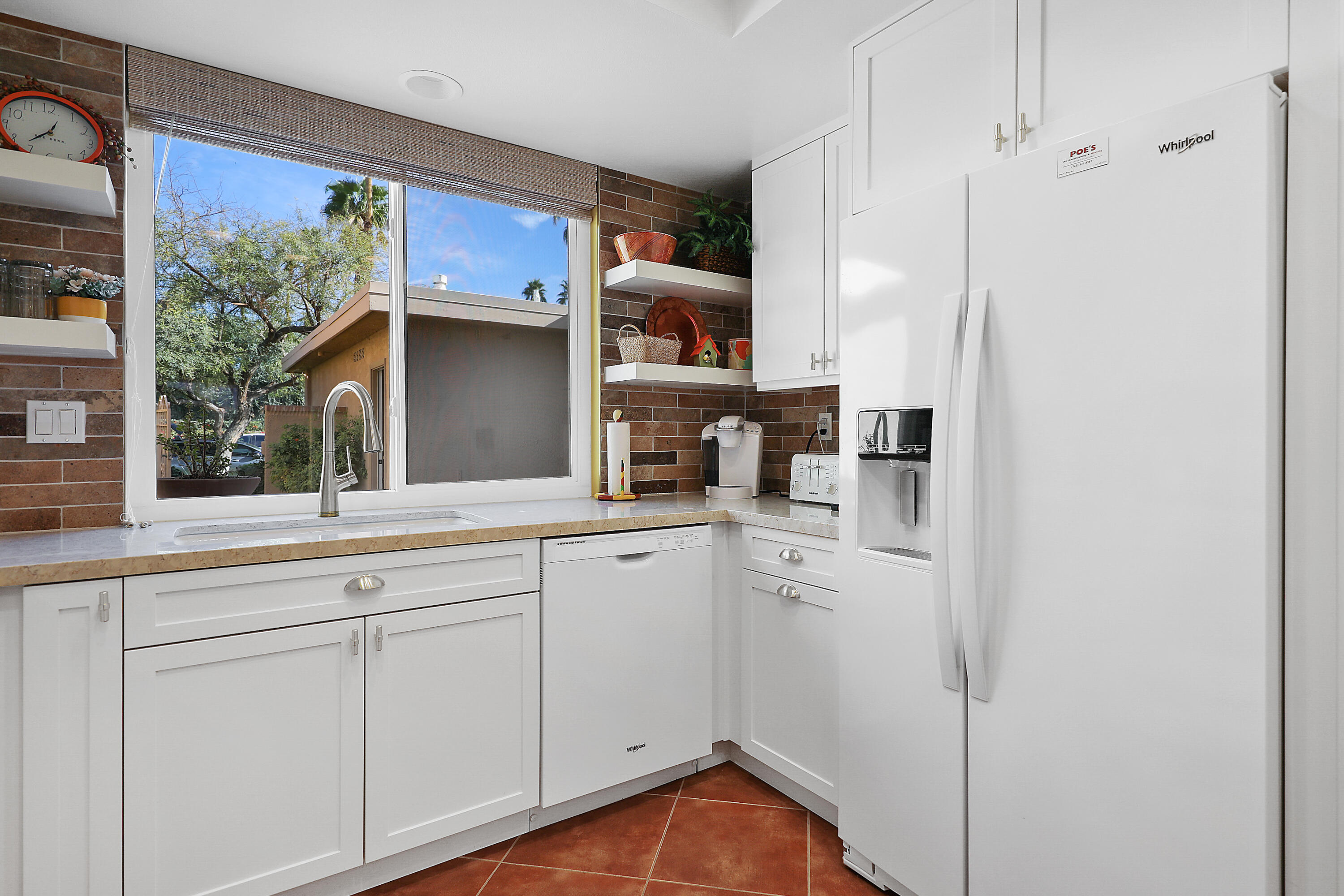23 La Ronda Drive Rancho Mirage, CA 92270 - Photo 12 of 34 a kitchen with white cabinets and a sink