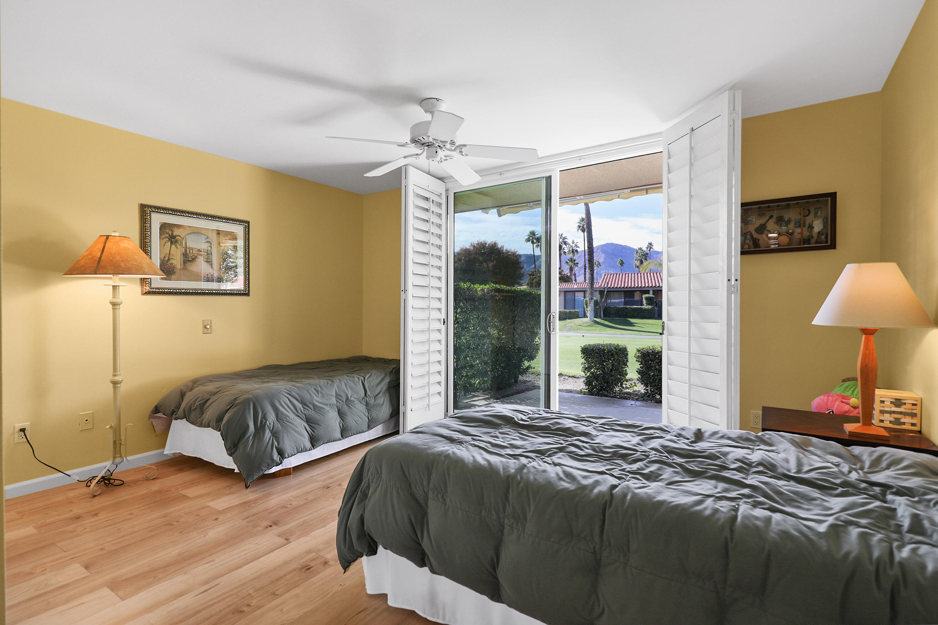 23 La Ronda Drive Rancho Mirage, CA 92270 - Photo 14 of 34 a bedroom with a bed and a chandelier